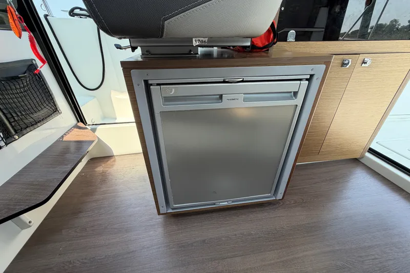 Slide: The Image of Interior of 2020 Jeanneau NC Sport 895 featuring a compact Dometic refrigerator. - 61