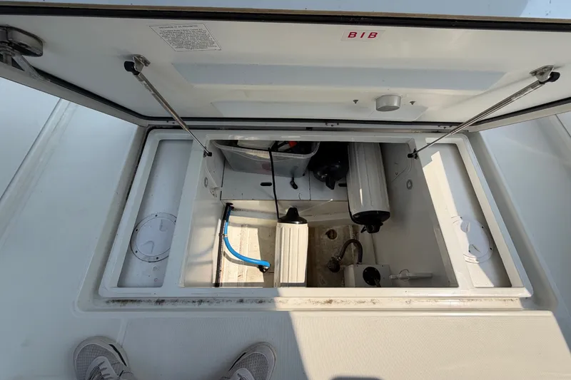 Slide: The Image of Open storage compartment on a 2020 Jeanneau NC Sport 895 boat, showing interior equipment. - 52