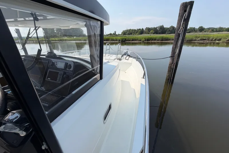 Slide: The Image of 2020 Jeanneau NC Sport 895 docked on calm water, showcasing sleek design and navigation equipment. - 39