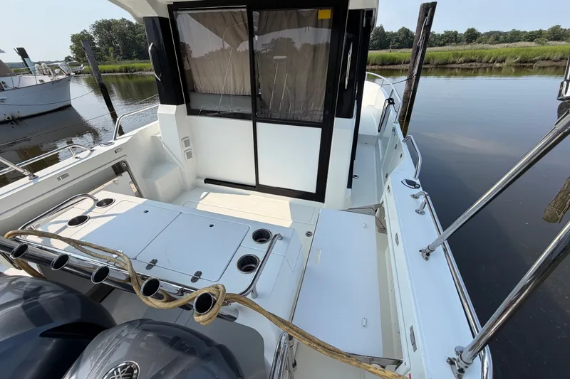 Slide: The Image of 2020 Jeanneau NC Sport 895 boat docked, featuring spacious deck and dual outboard motors. - 6