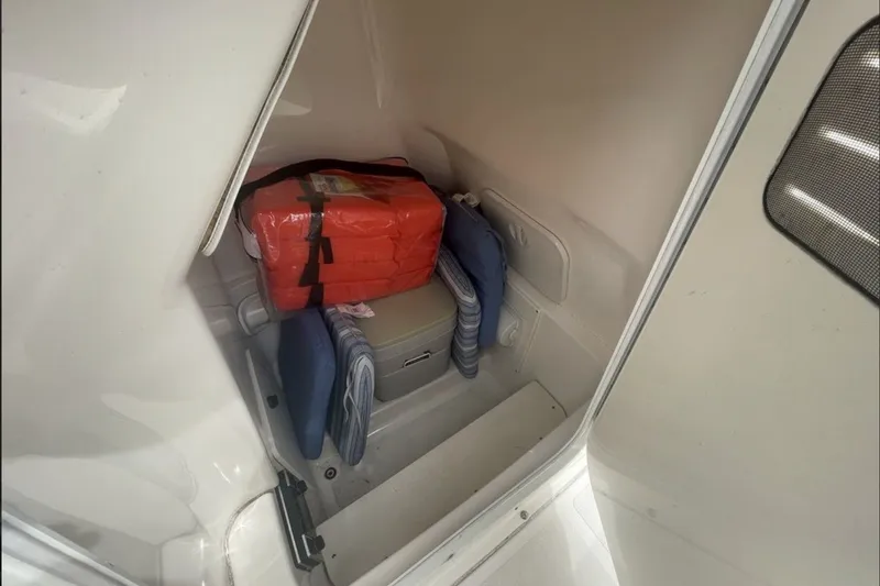 Slide: The Image of Interior storage of 2013 Pursuit C 230 Center Console with life jackets and cushions. - 9