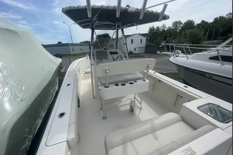 Slide: The Image of 2013 Pursuit C 230 Center Console boat with seating and console, docked outdoors. - 7