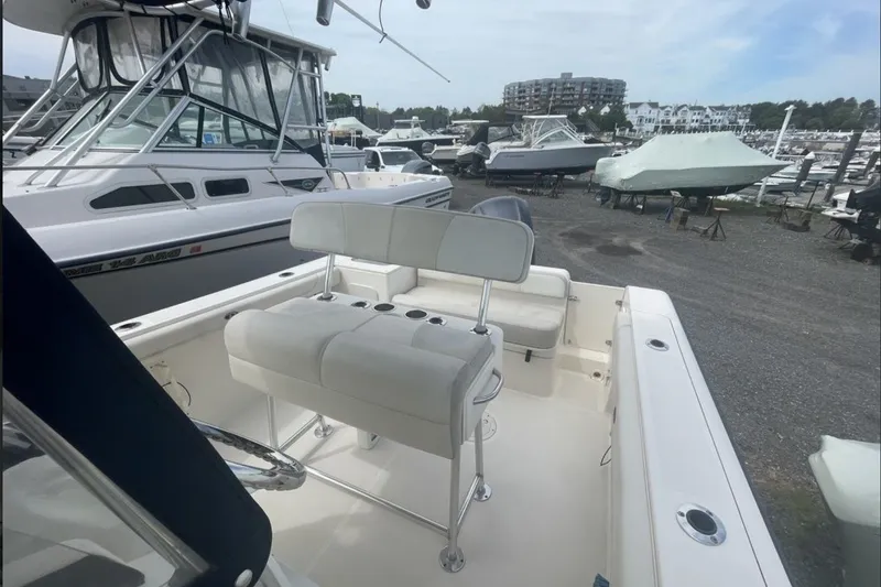 Slide: The Image of 2013 Pursuit C 230 Center Console boat with seating, docked in a marina. - 8