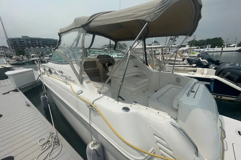 Slide: The Image of 2000 Sea Ray 270 Sundancer boat docked at marina, featuring covered seating area. - 3