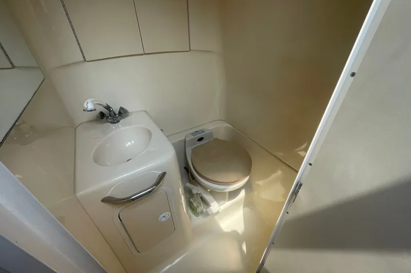Slide: The Image of Compact bathroom in 2000 Sea Ray 270 Sundancer boat, featuring sink and toilet. - 13