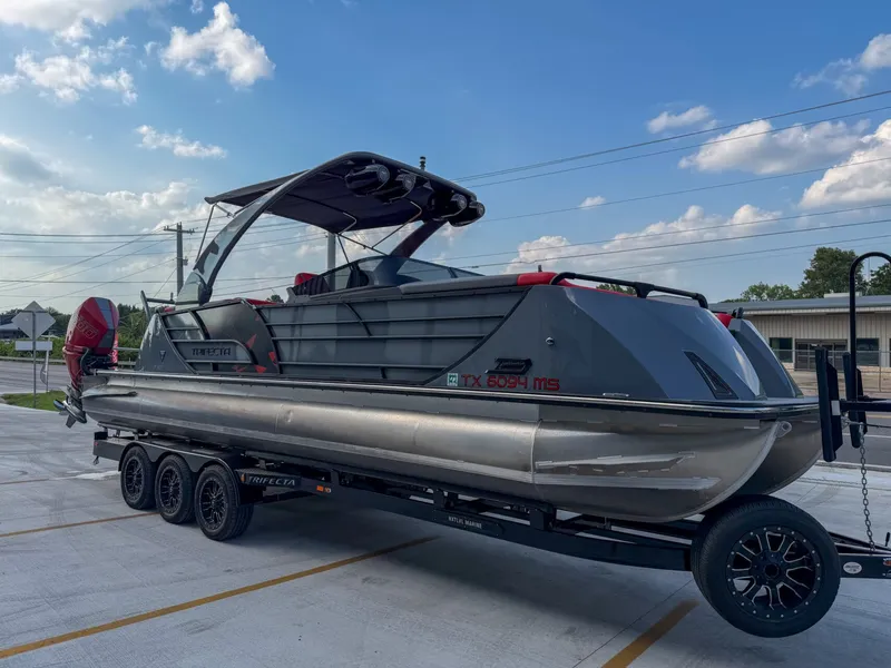 Slide: The Image of A modern Trifecta 25 SPORT RF9 DC 3.0 ARCH pontoon boat on a trailer, ready for adventure. - 7