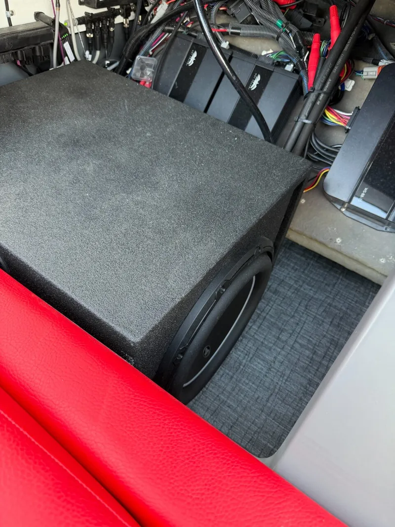 Slide: The Image of A black speaker is installed in a boat, surrounded by red seating and wiring. - 19