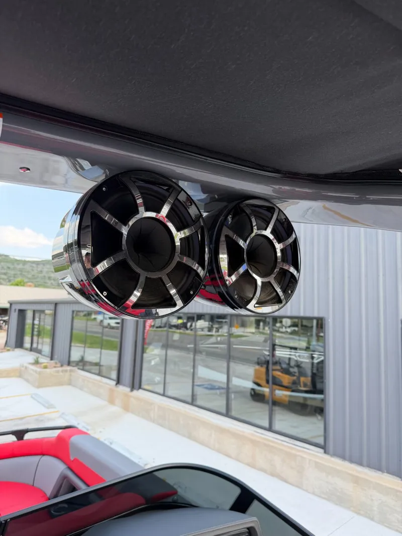 Slide: The Image of Two large speakers are mounted on a boat frame. Buildings are visible in the background. - 17