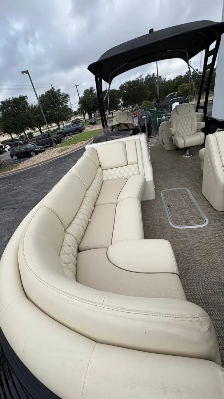 Slide: The Image of The image shows the interior of a 2015 Bennington 2575 QCW with beige leather seating and a black canopy. - 11