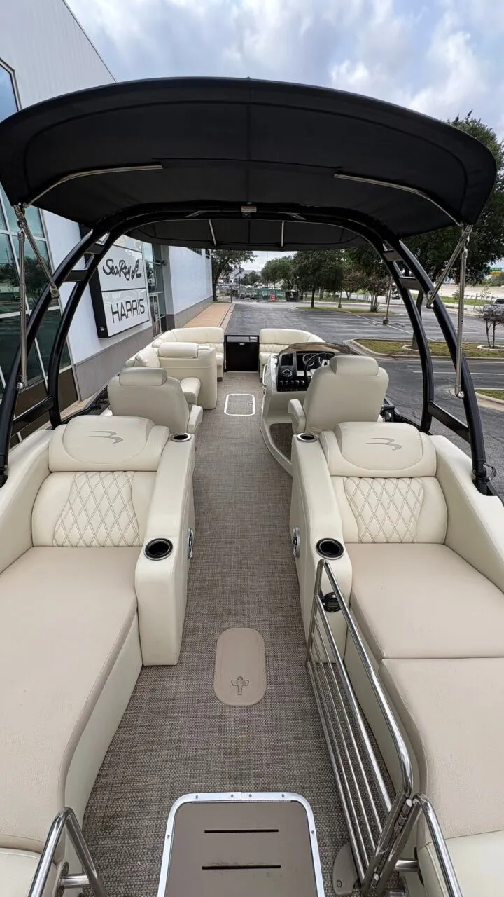 Slide: The Image of The image shows the interior of a 2015 Bennington 2575 QCW with beige seating and a black canopy. - 13