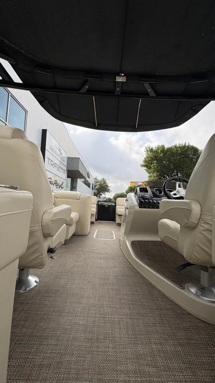 Slide: The Image of Interior view of a 2015 Bennington 2575 QCW with beige seating and a helm station. - 16