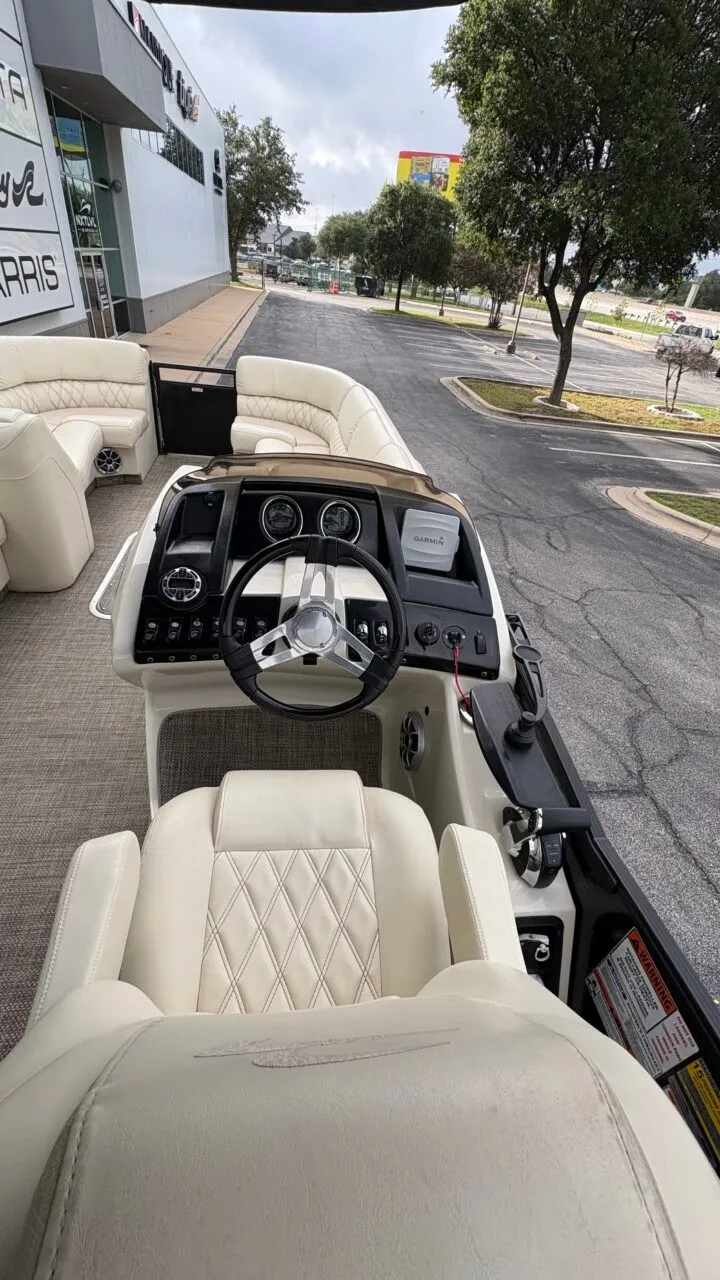Slide: The Image of The image shows the cockpit of a 2015 Bennington 2575 QCW with luxurious seating and a modern helm. - 15