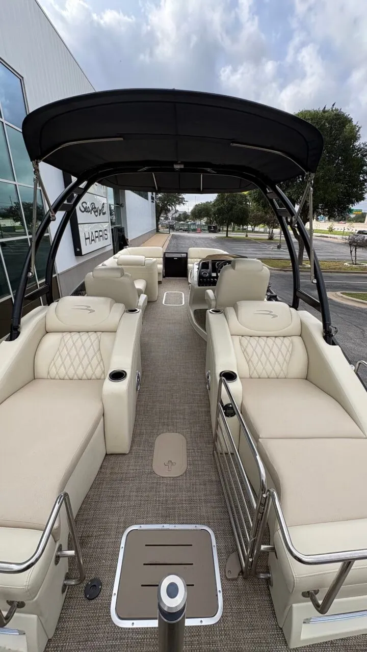 Slide: The Image of A luxurious pontoon boat with beige upholstery and a black canopy, parked in front of a building. - 14