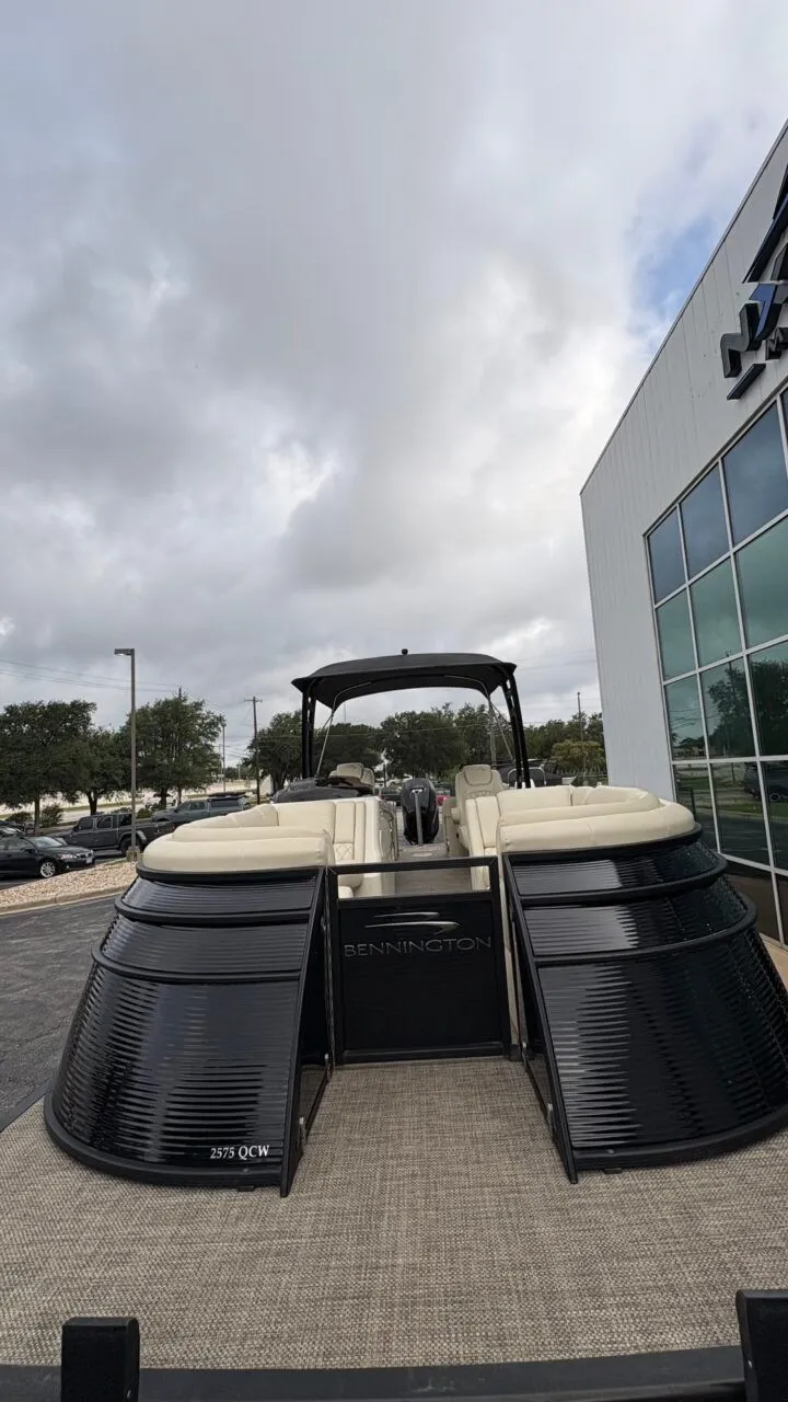 Slide: The Image of A 2015 Bennington 2575 QCW pontoon boat is parked in a lot in front of a building. - 7