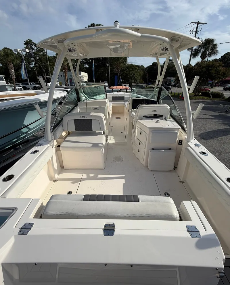 Slide: The Image of The image shows the cockpit of a 2021 Cobia 240 Dual Console boat with seating and storage. - 18