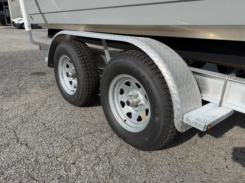 Slide: The Image of A 2021 Cobia 240 Dual Console boat on a trailer with dual axles and sturdy tires. - 38