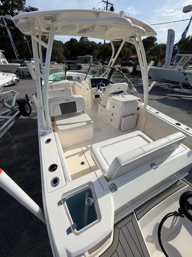 Slide: The Image of The image shows a 2021 Cobia 240 Dual Console. It features white upholstery and a modern cockpit. - 21