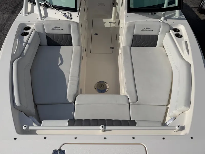 Slide: The Image of The 2021 Cobia 240 Dual Console features a spacious, cushioned seating arrangement on the foredeck. - 5