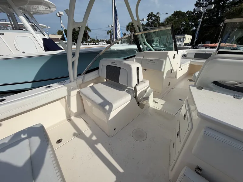 Slide: The Image of The image shows the cockpit of a 2021 Cobia 240 Dual Console boat with beige seating. - 20