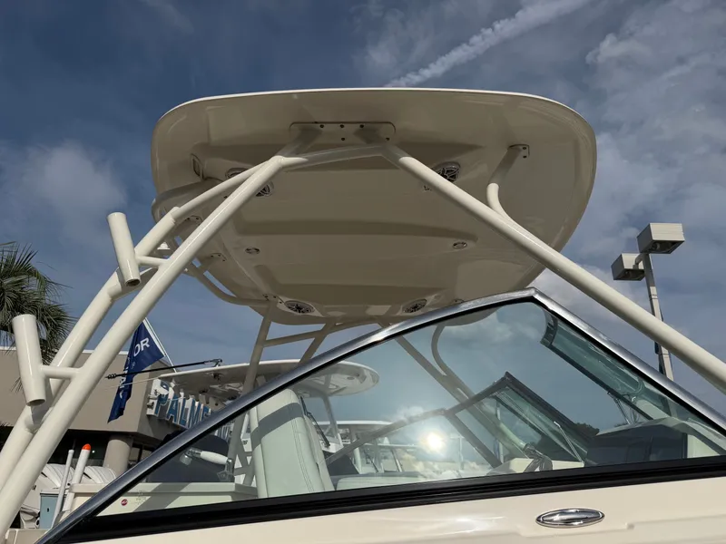 Slide: The Image of A 2021 Cobia 240 Dual Console boat featuring a sturdy T-top and clear windows. - 28