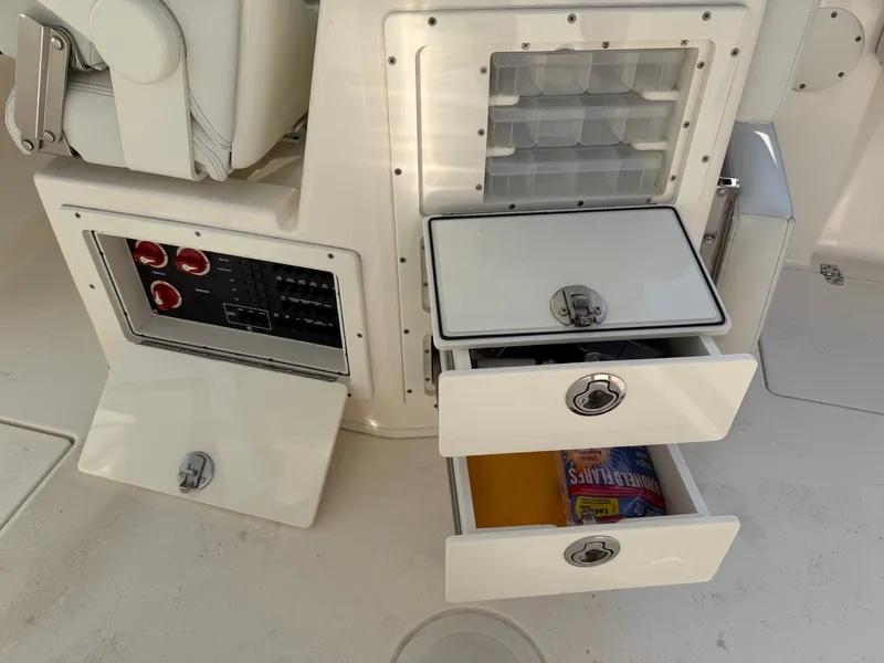 Slide: The Image of The image shows the storage area of a 2021 Cobia 240 Dual Console boat with open drawers. - 22
