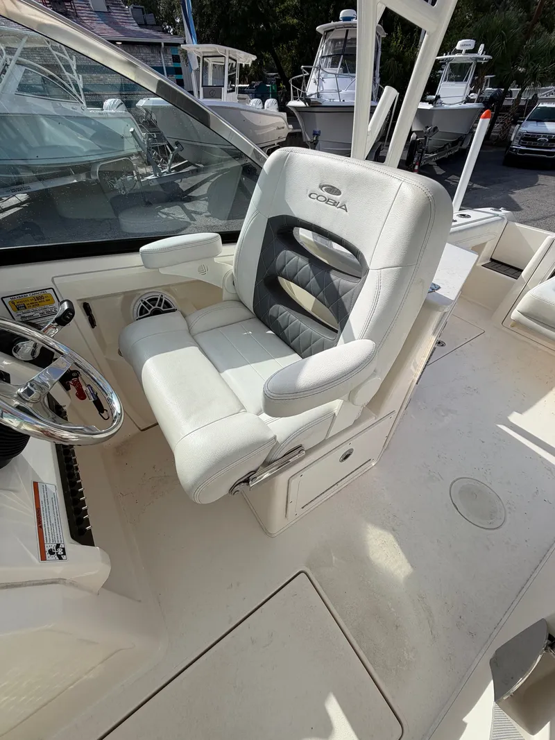 Slide: The Image of The 2021 Cobia 240 Dual Console features a luxurious white captain's chair with armrests. - 12