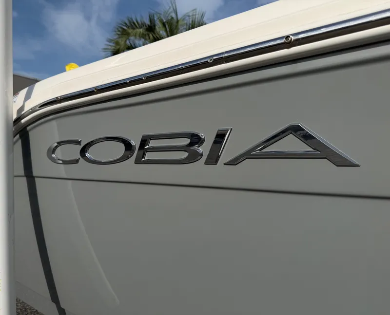 Slide: The Image of Close-up of the 2021 Cobia 240 Dual Console boat with a shiny logo. - 31