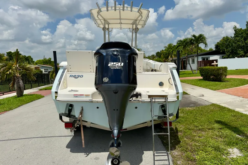 Slide: The Image of 2020 Robalo R230 Center Console boat with powerful 250 horsepower engine, parked outdoors. - 2