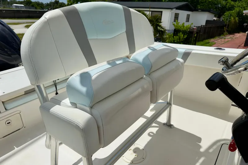 Slide: The Image of 2020 Robalo R230 Center Console boat seating with white and light blue cushions. - 22