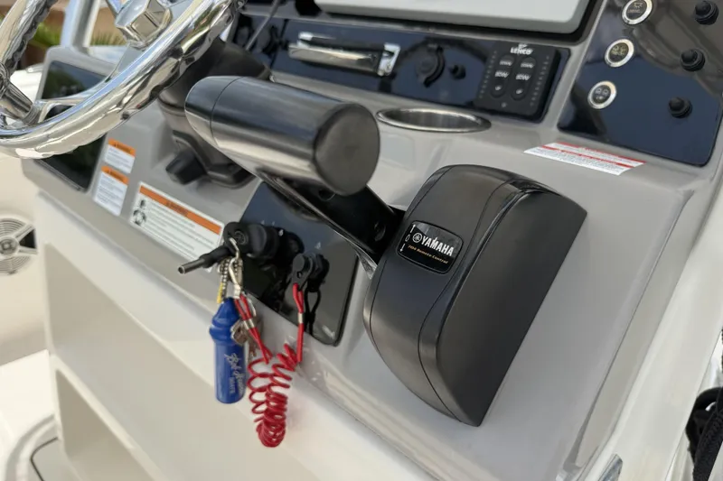 Slide: The Image of 2020 Robalo R230 Center Console boat dashboard with Yamaha controls and ignition keys. - 16