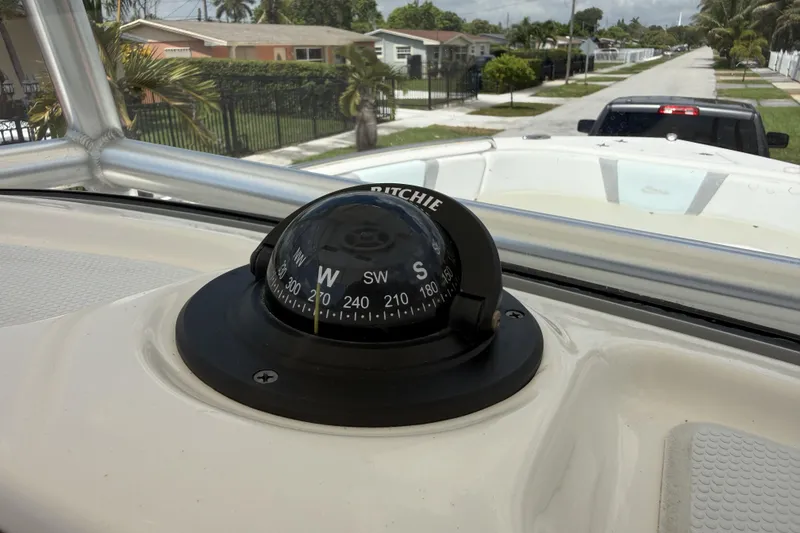 Slide: The Image of Compass on 2020 Robalo R230 Center Console boat, parked in a residential area. - 18