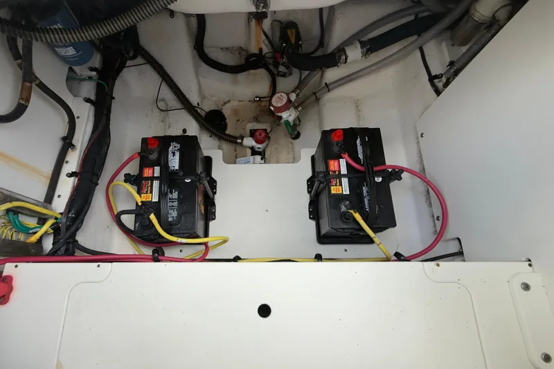 Slide: The Image of 2020 Robalo R230 Center Console boat battery compartment with wiring and connections. - 48