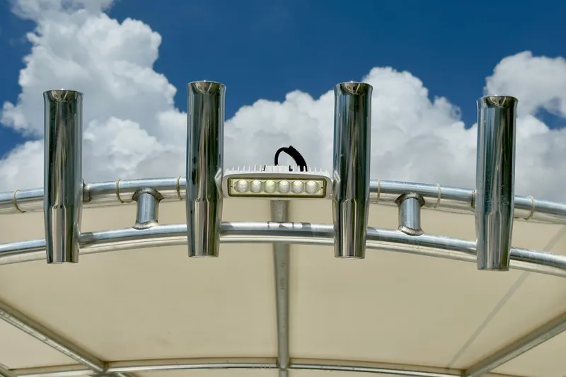 Slide: The Image of Robalo R230 Center Console 2020 boat with rod holders and LED light against cloudy sky. - 39