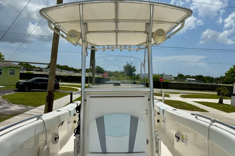 Slide: The Image of 2020 Robalo R230 Center Console boat with T-top, parked in a residential area. - 36