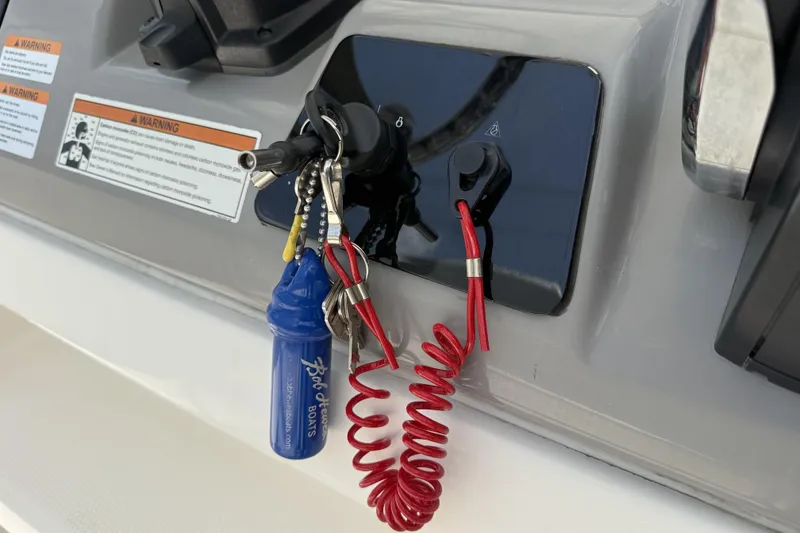 Slide: The Image of 2020 Robalo R230 Center Console ignition with keys and safety lanyard. - 17