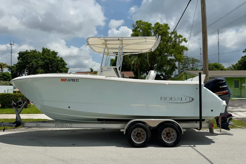 Slide: The Image of 2020 Robalo R230 Center Console boat on trailer, parked outdoors. - 49