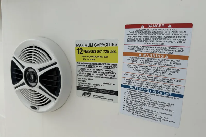 Slide: The Image of 2020 Robalo R230 Center Console boat capacity and safety warning labels with speaker. - 46