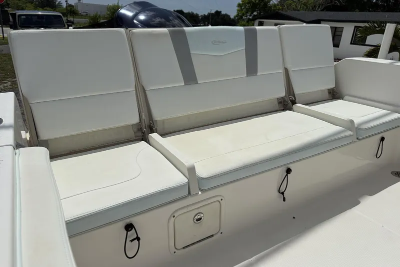 Slide: The Image of 2020 Robalo R230 Center Console boat seating, featuring white cushioned seats and storage compartments. - 24