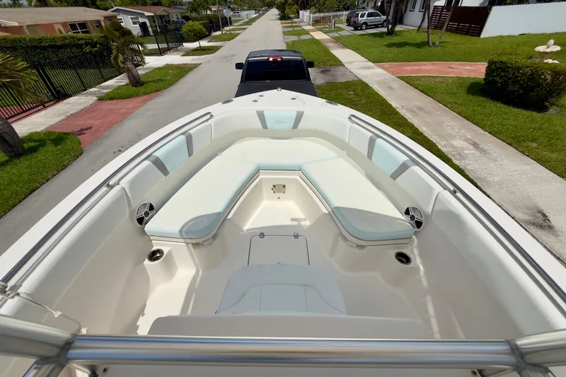 Slide: The Image of 2020 Robalo R230 Center Console boat with spacious seating, parked on a residential street. - 30