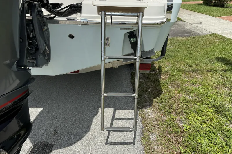 Slide: The Image of 2020 Robalo R230 Center Console boat with extended ladder on pavement. - 3