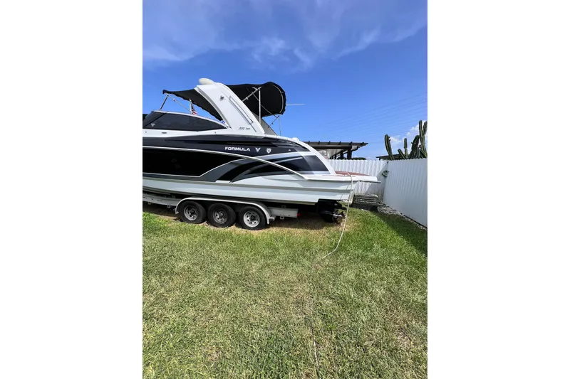 Slide: The Image of 2015 Formula 330 Crossover Bowrider on trailer, parked on grass under blue sky. - 31