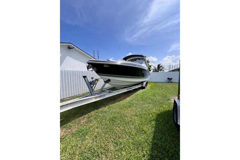 Slide: The Image of 2015 Formula 330 Crossover Bowrider on trailer, parked on grass under clear blue sky. - 29