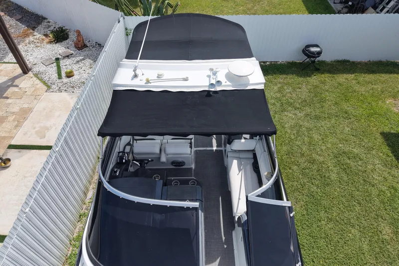 Slide: The Image of 2015 Formula 330 Crossover Bowrider with black canopy, parked on grass beside a white fence. - 7