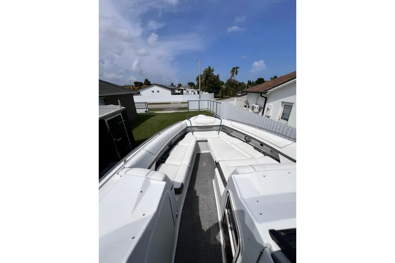 Slide: The Image of 2015 Formula 330 Crossover Bowrider with spacious seating in a residential driveway. - 24