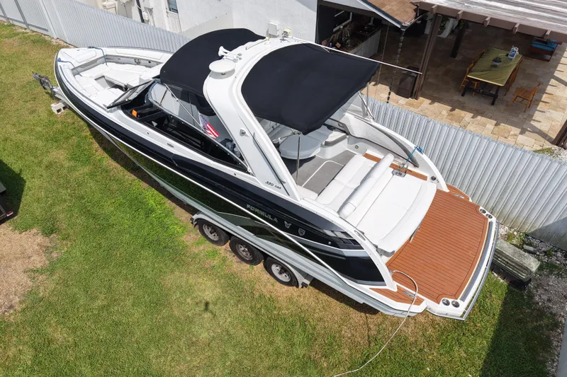 Slide: The Image of 2015 Formula 330 Crossover Bowrider boat on trailer, parked on grass. - 2