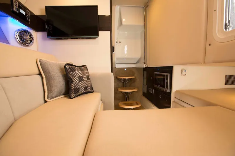 Slide: The Image of Manufacturer Provided Image: Interior of 2016 Formula 330 Crossover Bowrider with beige seating, TV, and modern amenities. - 11