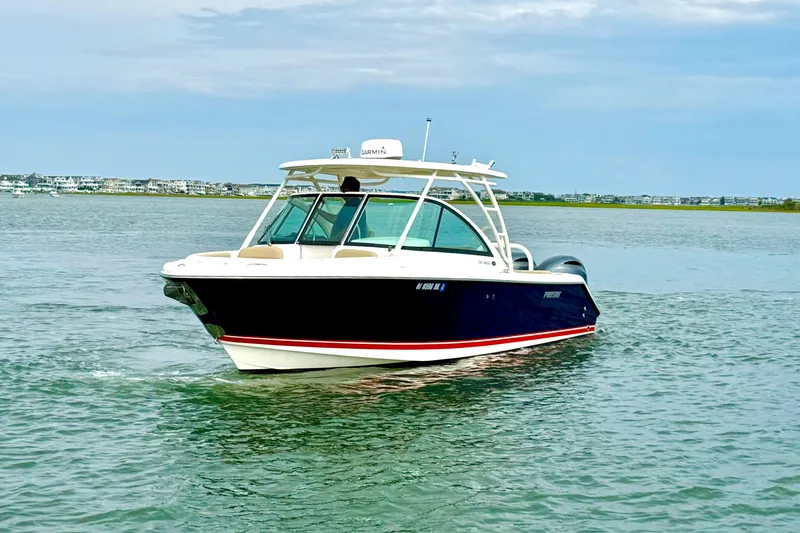 Slide: The Image of 2016 Pursuit DC 265 Dual Console boat cruising on calm waters. - 5