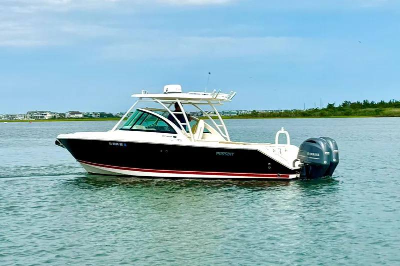 The Image of 2016 Pursuit DC 265 Dual Console boat on calm water with Yamaha engines. - 1