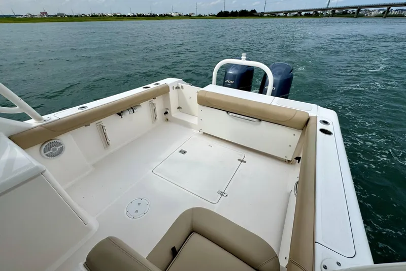 Slide: The Image of 2016 Pursuit DC 265 Dual Console boat with spacious seating and twin engines on open water. - 11