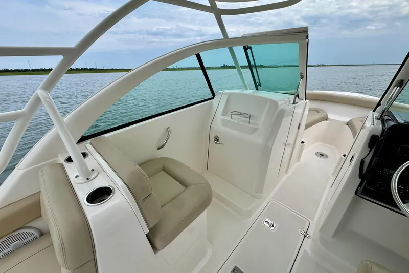 Slide: The Image of 2016 Pursuit DC 265 Dual Console boat interior with seating and open water view. - 8